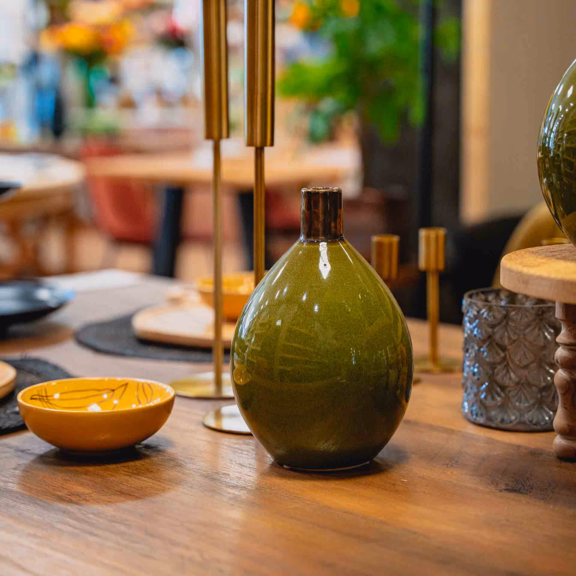 Tavola con vaso in vetro verde nello showroom